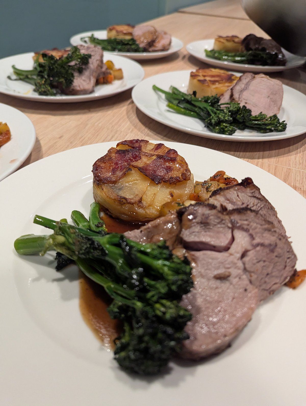 Tallerkener med stek, fondantpotet, brokkolini og saus, klare til servering